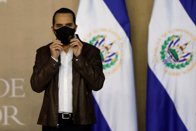 El Salvador’s President Nayib Bukele puts on a protective mask