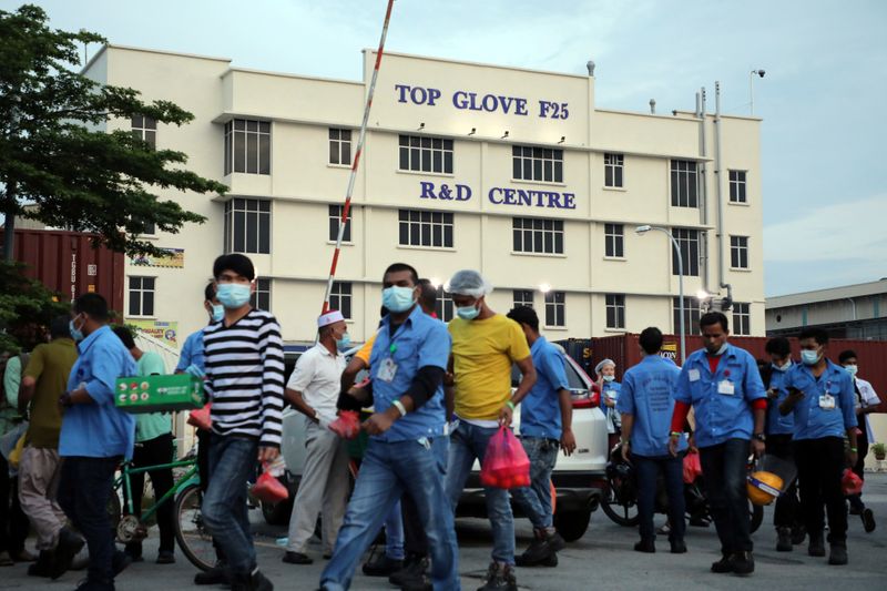 FILE PHOTO: Workers leave a Top Glove factory after their