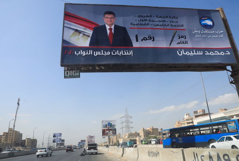 Cars drive near a billboard of the election campaign member