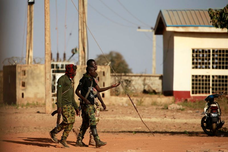 Military men walk inside the Government Science school in Kankara
