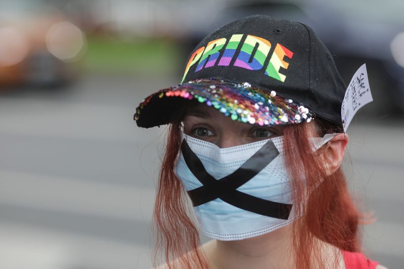 Girl wearing a PRIDE cap and a face mask bearing