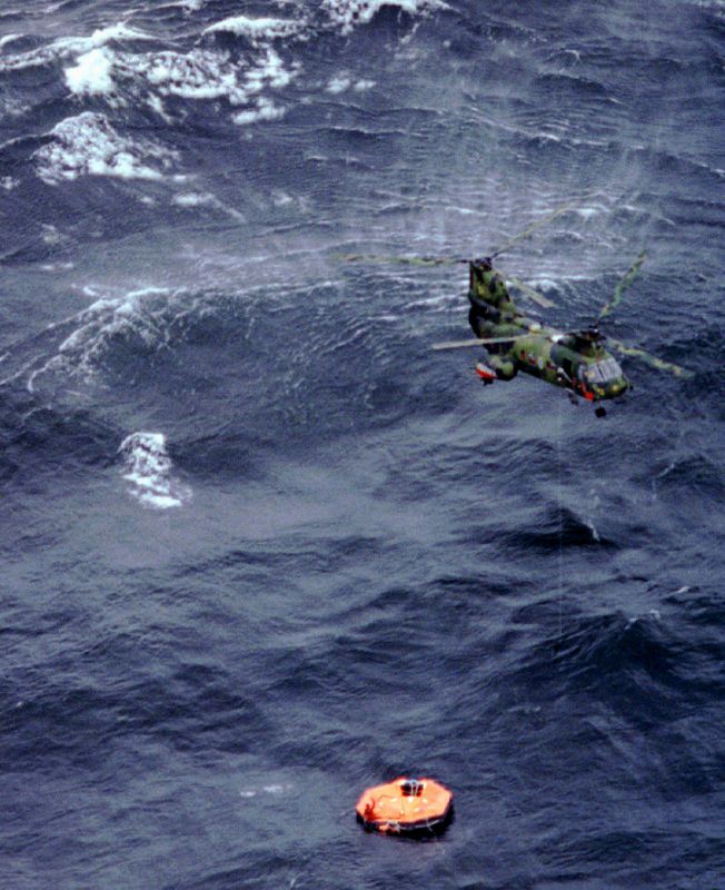 FILE PHOTO: A helicopter circles an over turned lifeboat from