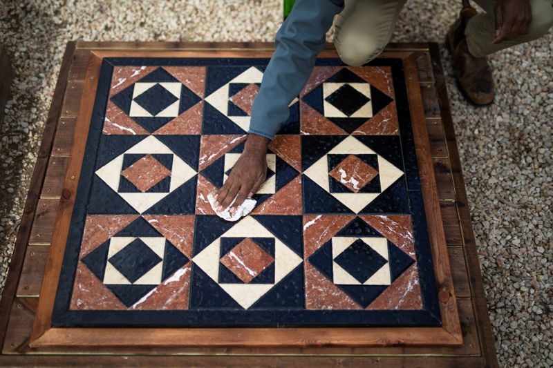 Israeli archaeologist Assaf Avraham polishes a replica of flooring of