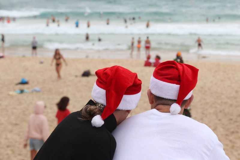People wear Santa hats on Christmas Day at Bondi Beach