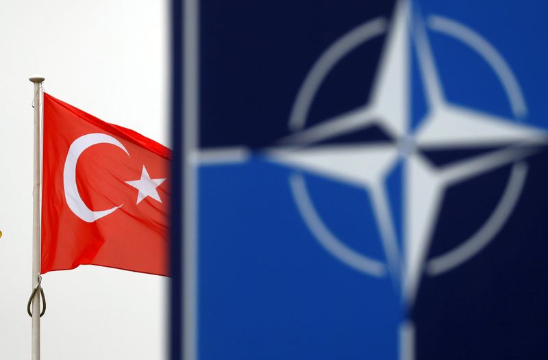 FILE PHOTO: A Turkish flag flies next to NATO logo