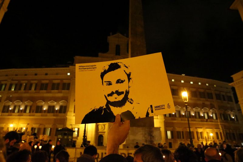 A man holds a placard during a vigil to commemorate