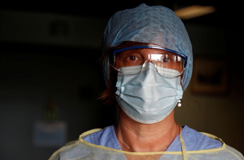 Belgian doctor poses with her protective gear in a hospital