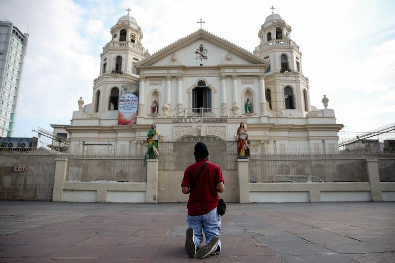 FILE PHOTO: Filipino Catholic pray outside a closed church amid