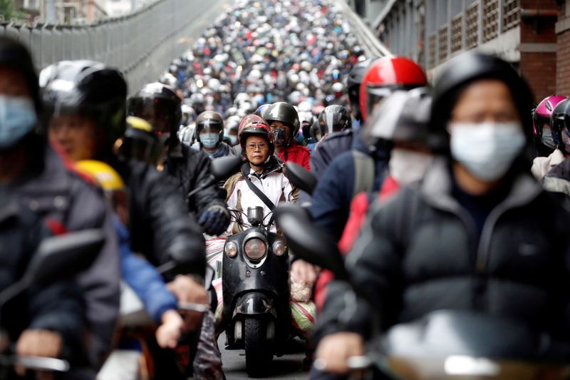 FILE PHOTO:  Commuters wear face masks to protect themselves