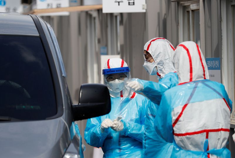 FILE PHOTO: Medical staff in protective gear prepare to take
