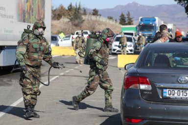 FILE PHOTO: Georgian servicemen sanitize vehicles to prevent the spread