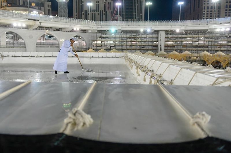 A worker cleans and sterilises the roof of Kaaba, following