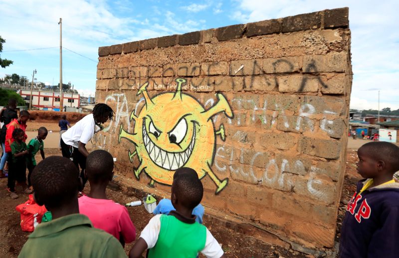 Children look on as Brian Musasia Wanyande, an artist from