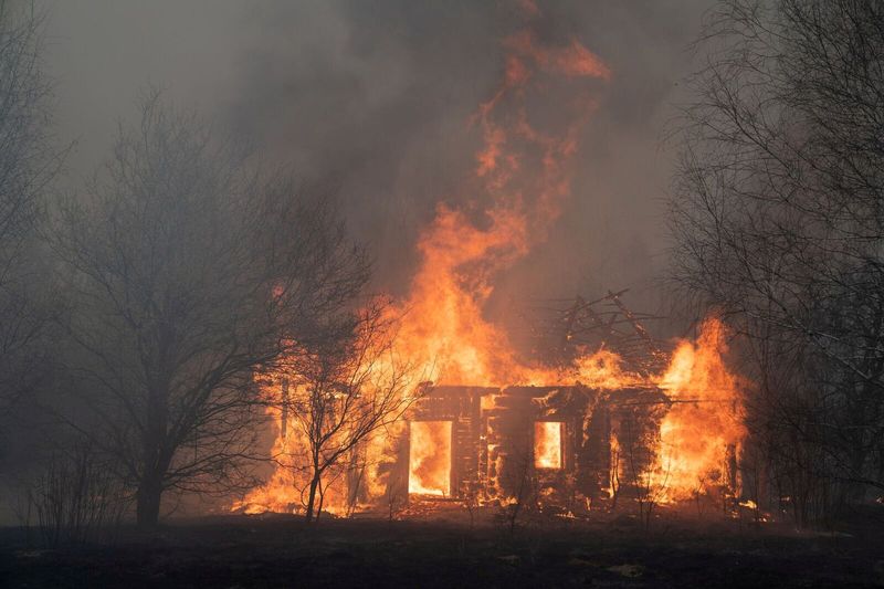 FILE PHOTO: A view shows a wooden house on fire