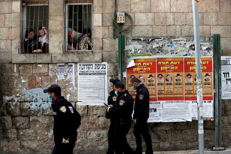 FILE PHOTO: Israeli policemen wearing masks talk to residents from