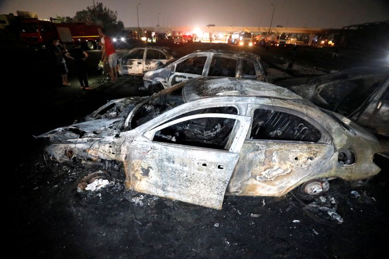 Burned vehicles are seen following a fire that broke out