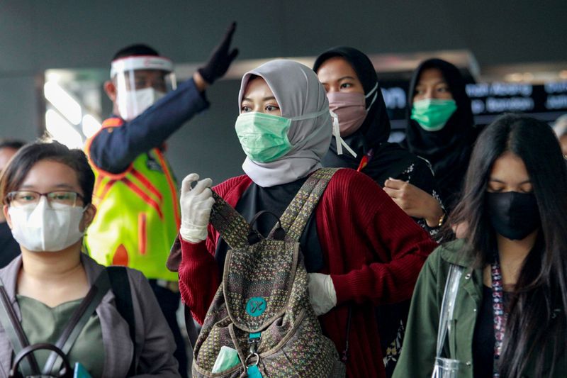 FILE PHOTO: People are pictured wearing protective face masks as