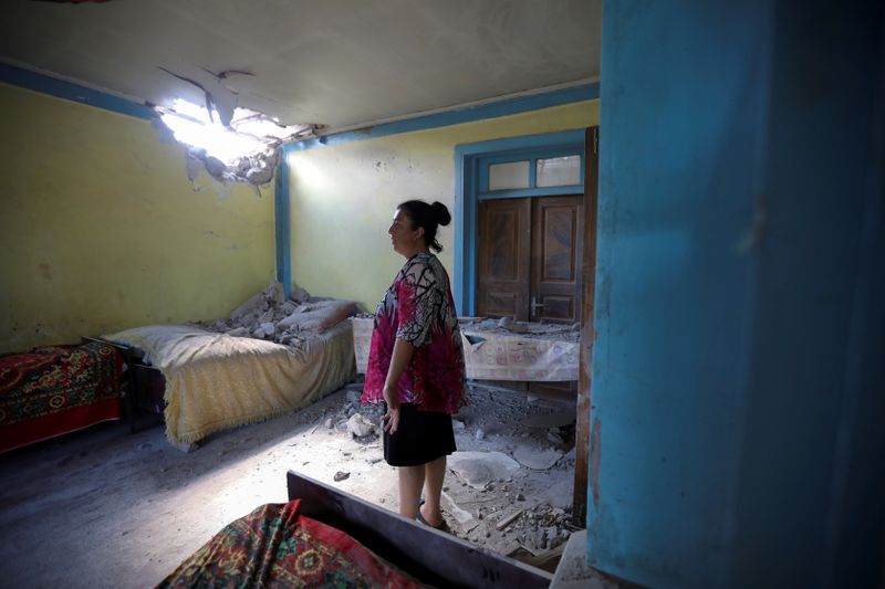 FILE PHOTO: A woman stays in a house damaged by
