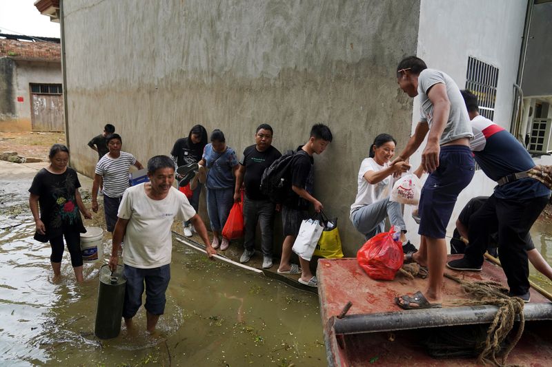 Residents stranded by floodwaters line up to get on a
