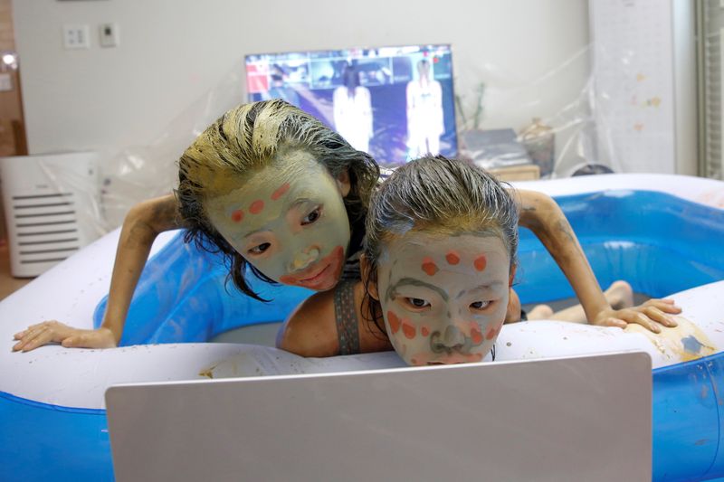 Children play in a mud pool during the Online Boryeong