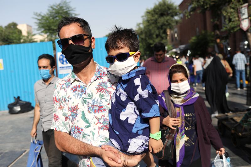 An Iranian man and his son wearing a protective face