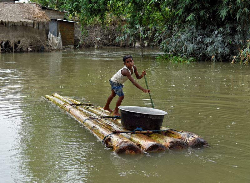 A boy transports a pot on a makeshift raft through