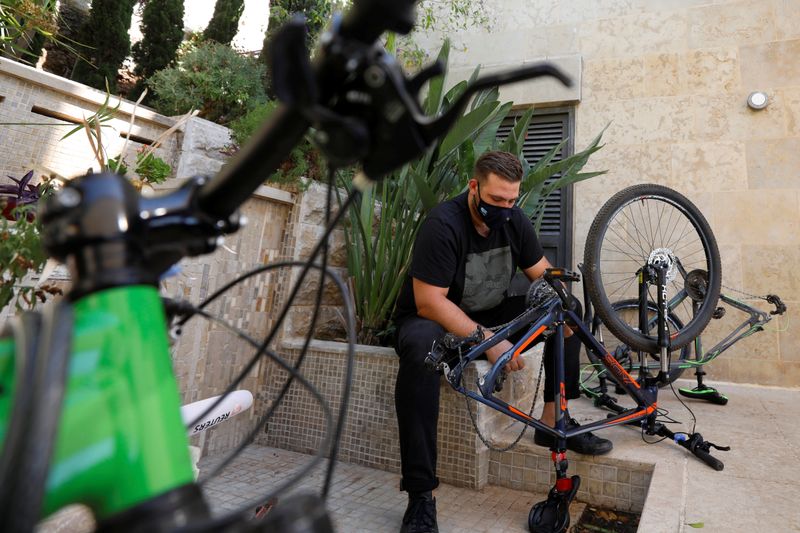 Palestinian cyclist Samer Kurdi inspects his damaged bicycle in Ramallah