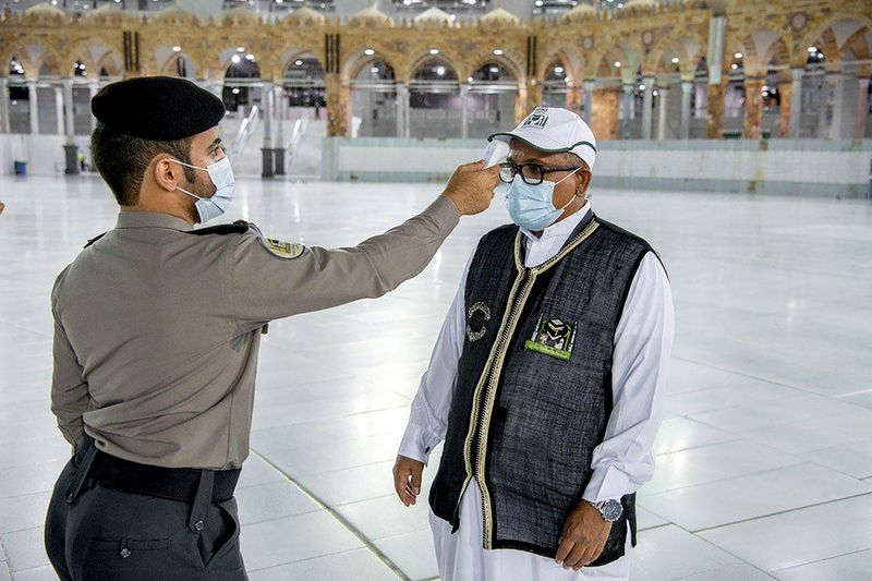 A security man checks the temperature of a worker as