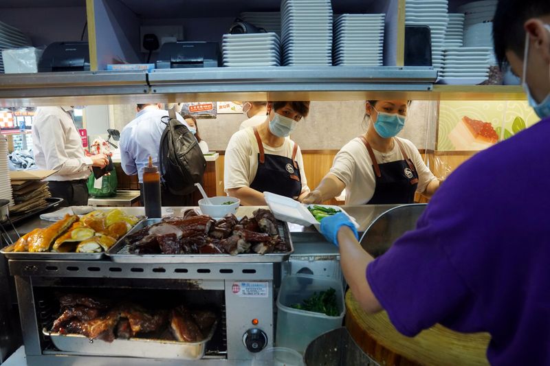 FILE PHOTO: Staff members prepare takeaway food at a restaurant
