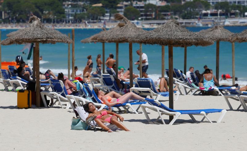 FILE PHOTO: People sunbathe in Magaluf beach