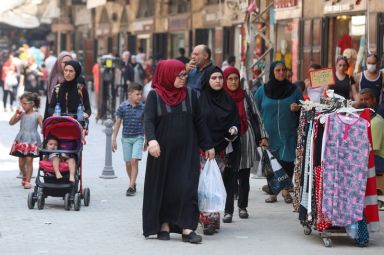 People walk at a souk ahead of the Eid al-Adha