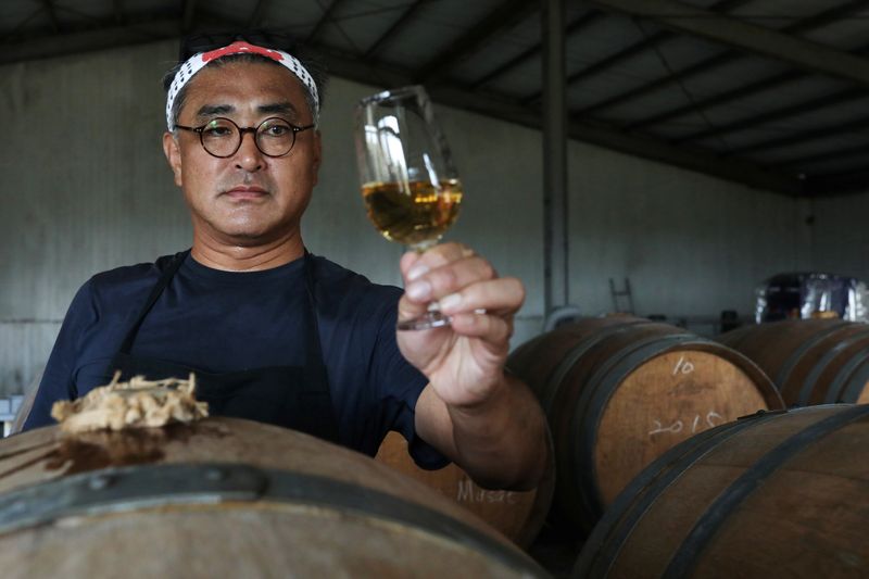Chen Chien-hao, 52, holds a glass of his wine at