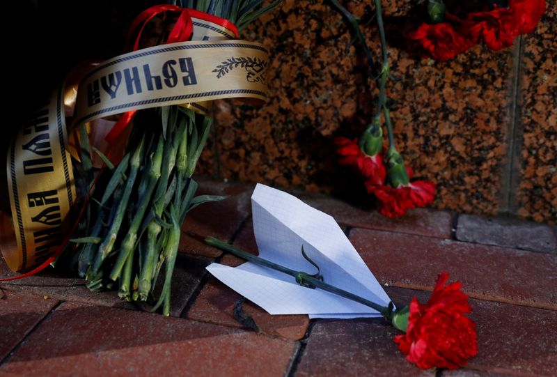 Flowers and a paper plane are placed outside the Iranian