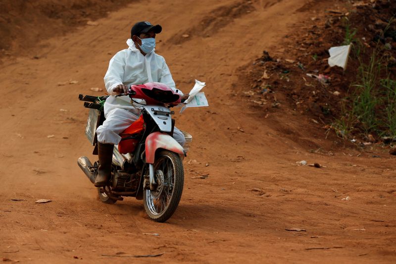 Worker wearing a protective suit rides a motorbike to the
