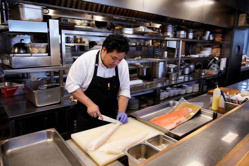 Chef and owner Austin Hu prepares frozen cod fish and