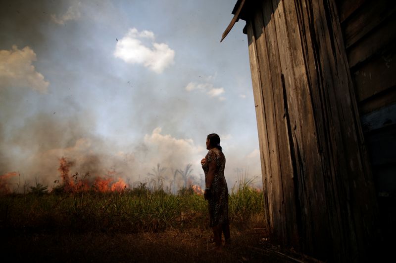 Miraceli de Oliveira reacts as the fire approaches their house