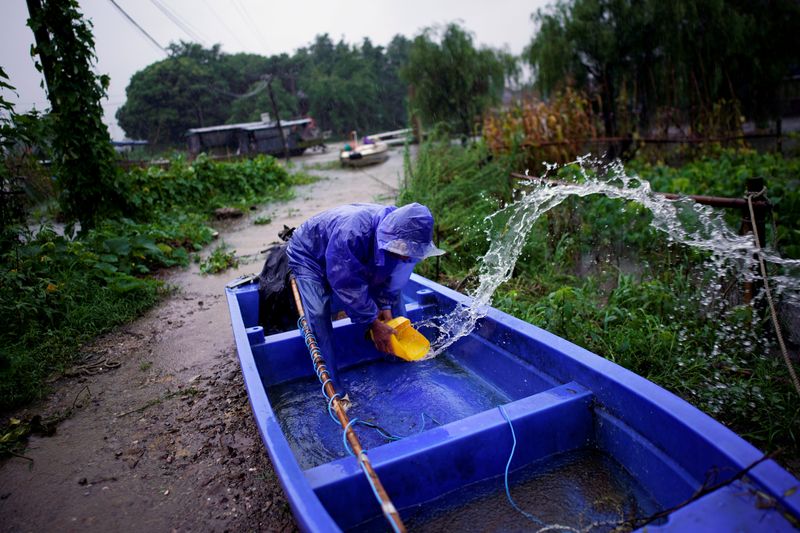 FILE PHOTO: Man removes water from inside a boat near