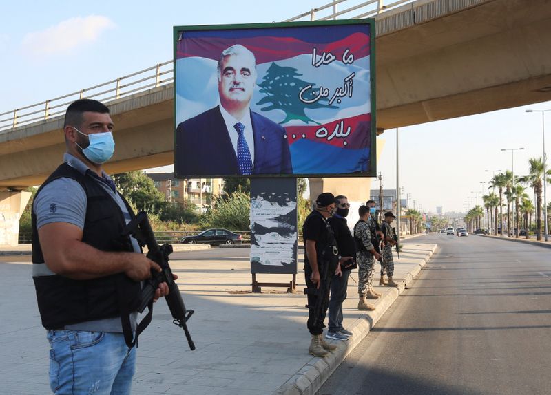 Members of security forces stand guard near a billboard depicting