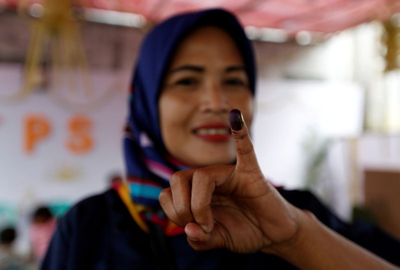 FILE PHOTO: An Indonesian woman shows her ink-stained finger after