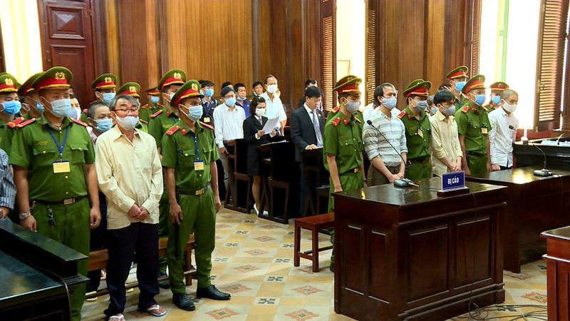 Defendants of Trieu Dai Viet group stand during their trial