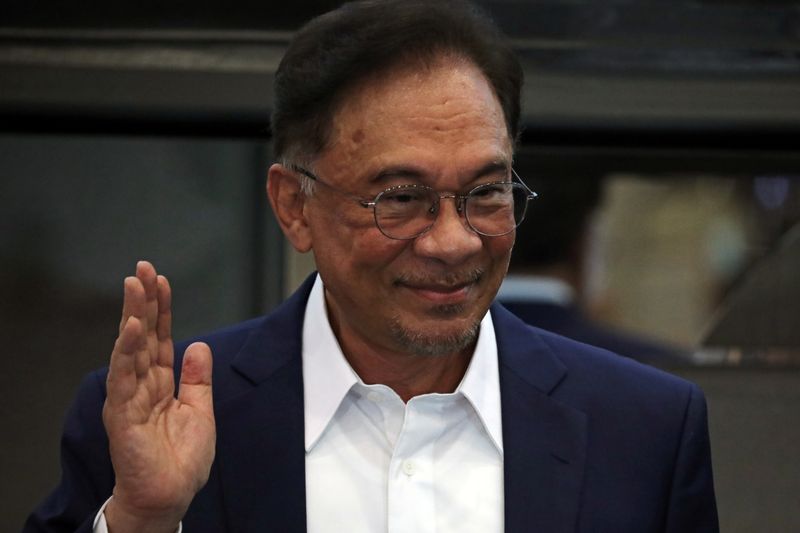 Malaysia opposition leader Anwar Ibrahim waves after a news conference