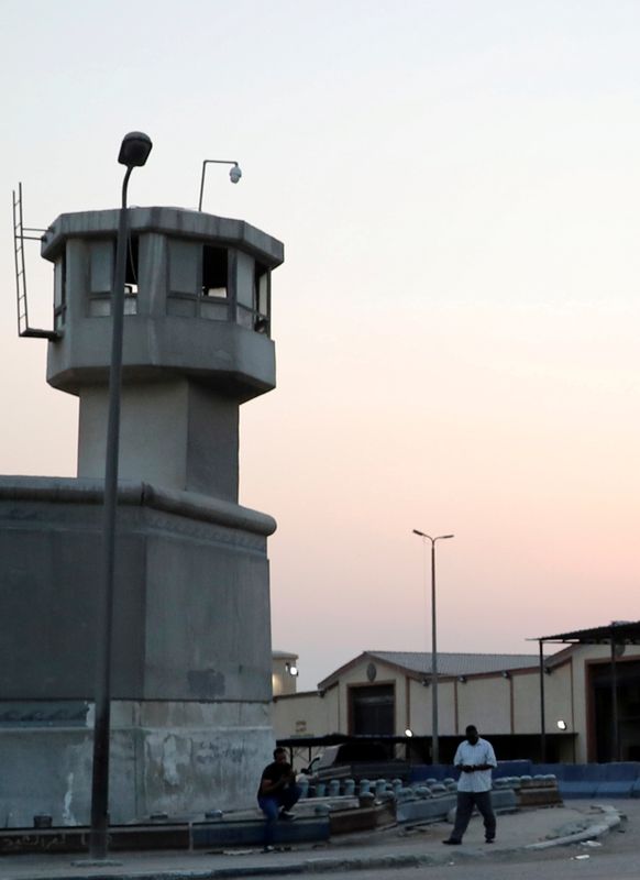 FILE PHOTO: People stand in front of security tower outside