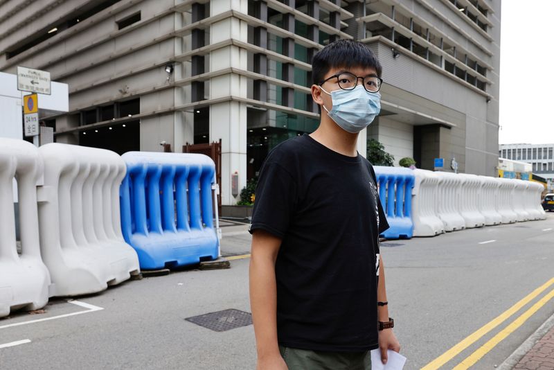 Pro-democracy activist Joshua Wong leaves a police station after being