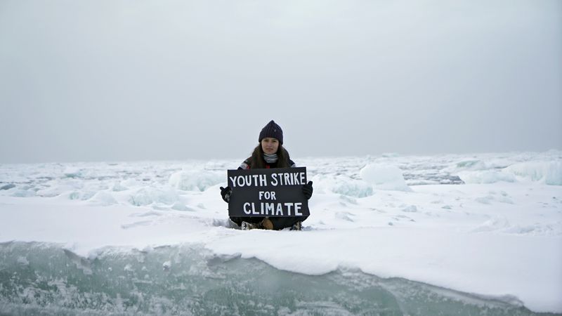 Environmental activist and campaigner Mya-Rose Craig holds a cardboard sign
