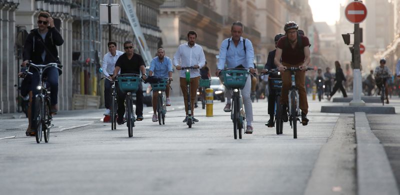 FILE PHOTO: People ride bicycles in the Rue de Rivoli