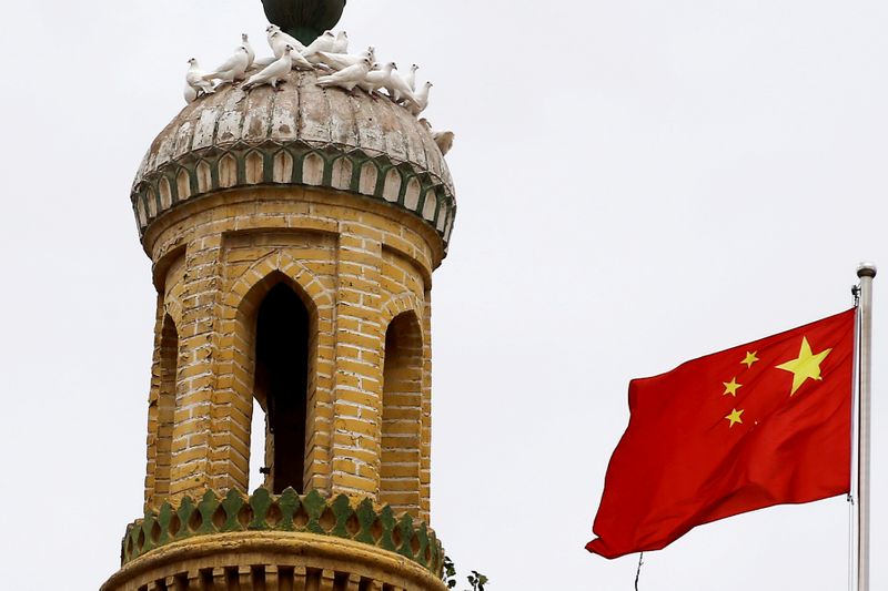 FILE PHOTO: A Chinese national flag flutters near a minaret