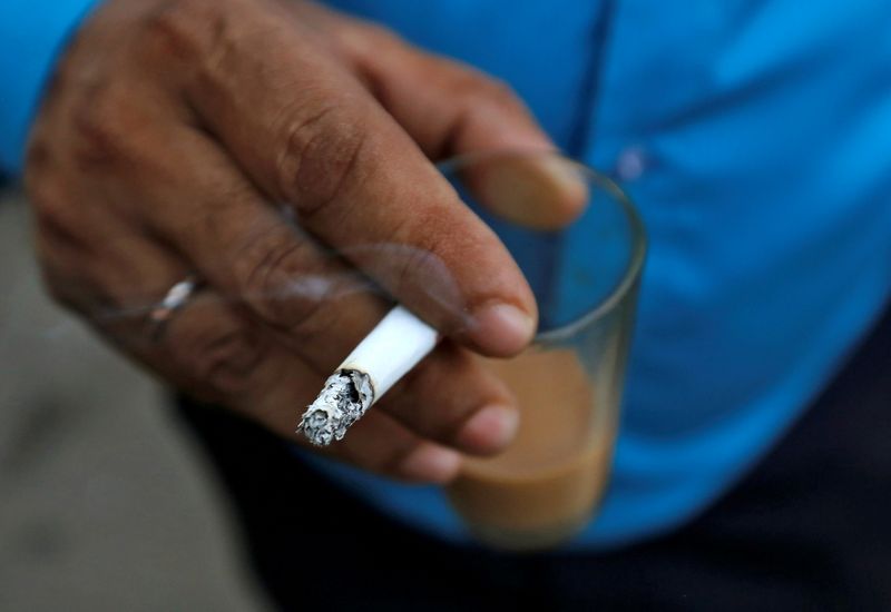 FILE PHOTO: A man smokes a cigarette along a road