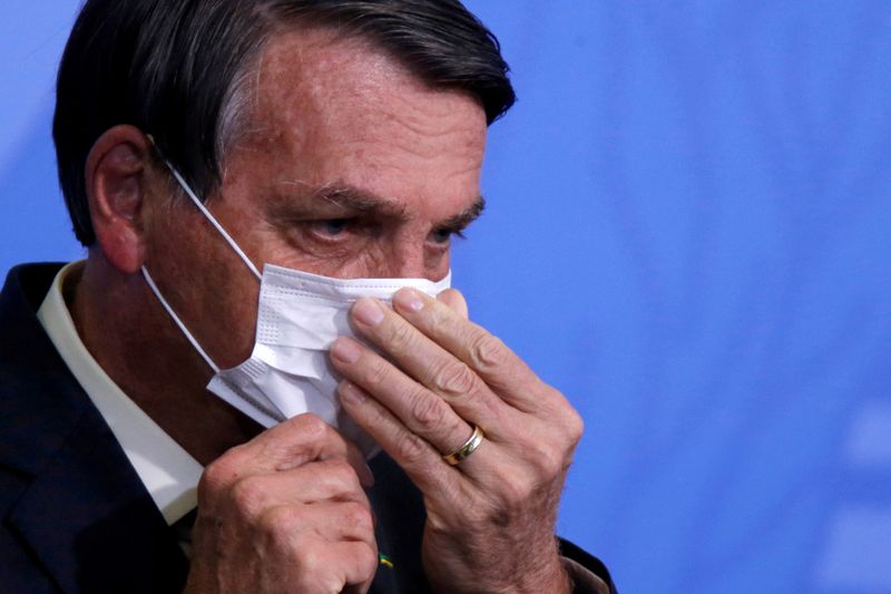 FILE PHOTO: Brazil’s  Bolsonaro looks on as he adjusts