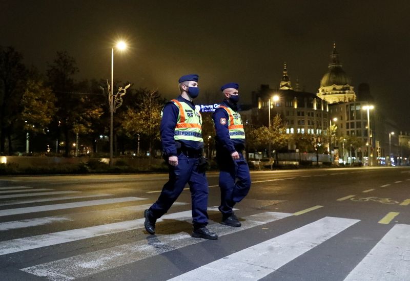 Police officers patrol during a night-time curfew imposed by the