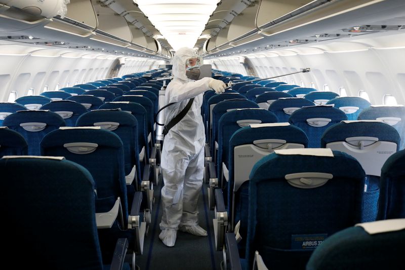 A health worker sprays disinfectant inside a Vietnam Airlines airplane